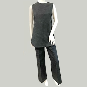 May include: A black sleeveless top and matching trousers set. The top has a rounded hem and a subtle floral pattern. The trousers are wide-legged and also feature the same floral design. The outfit is displayed on a mannequin.