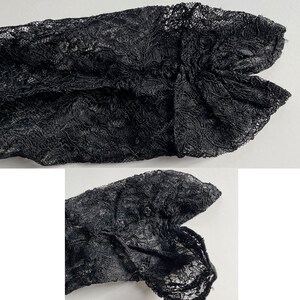 K&ouml;nnte beinhalten: Nahaufnahme von schwarzem Spitzenstoff mit aufwendigen floralen Mustern. Das zarte Material ist gerafft und geformt, wodurch ein strukturierter, geschichteter Effekt entsteht. Das Bild hebt das detaillierte Design und das Spiel von Licht und Schatten auf dem Stoff hervor.