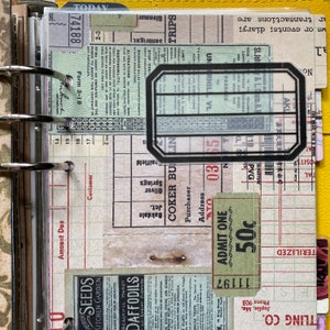 May include: A close-up of a vintage ticket stub with the text "ADMIT ONE 50c" printed on it. The ticket is green and white with black text. The ticket is attached to a page in a vintage journal.