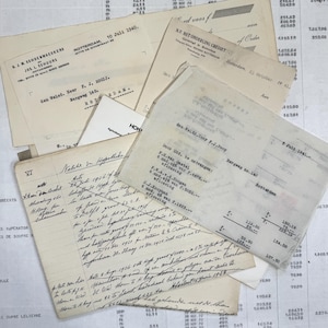 Puede incluir: Un conjunto de documentos antiguos, incluyendo notas manuscritas, facturas y recibos, se encuentra disperso sobre una superficie. Los papeles varían en tamaño y forma, con texto visible en tinta negra. Algunos documentos datan de la década de 1940.