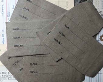 Peut inclure: Six enveloppes en papier brun avec les mots "NAME", "CLASS" et "AMOUNT" imprimés dessus. Les enveloppes sont empilées les unes sur les autres.