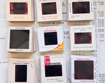 May include: A collection of vintage 35mm slides, featuring various subjects. The slides are in white cardboard frames with text in French and English. Some slides are labeled with locations like Florence and Paris.