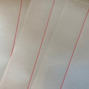 May include: Three sheets of white paper with red lines running diagonally across them.
