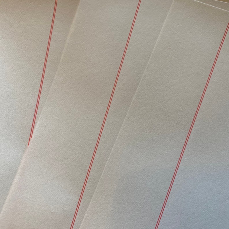 May include: Three sheets of white paper with red lines running diagonally across them.
