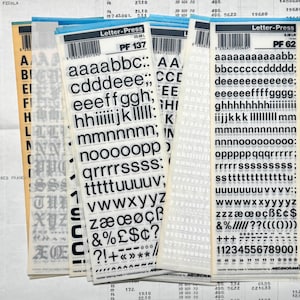 Peut inclure: Plusieurs feuilles de transfert de lettres avec des lettres, des chiffres et des symboles noirs et blancs. Les feuilles sont de la marque "Letter-Press" et portent divers codes. Idéal pour l'artisanat, le scrapbooking et les projets de typographie.
