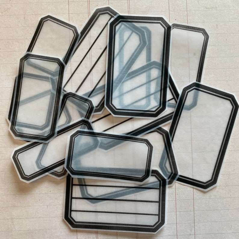 May include: A set of ten clear, rectangular, adhesive labels with black borders. The labels have a vintage, decorative look and are perfect for adding a touch of elegance to your projects.