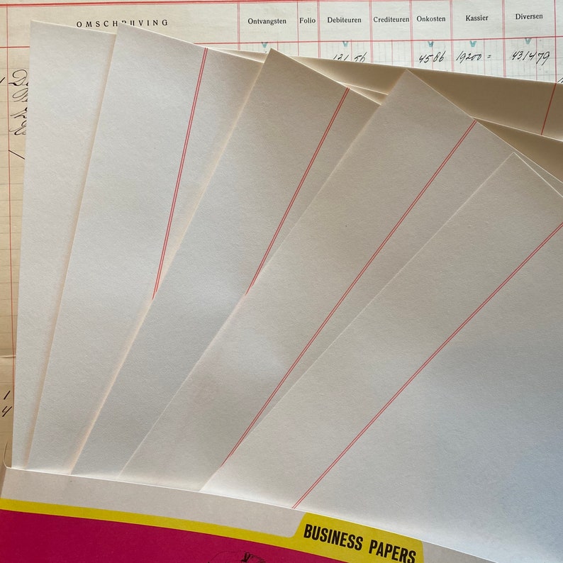 May include: A stack of blank white business papers with red lines. The papers are folded in half and are ready to be used for writing or printing.