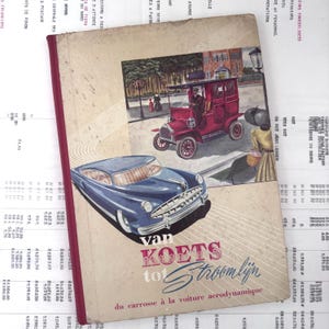 Op de afbeelding: Een hardcover boek met een beige kaft voorzien van een rode historische koets en een blauwe aerodynamische auto. De titel luidt van KOETS tot Stroomlijn, met de ondertitel du carrosse à la voiture aerodynamique in rode en blauwe tekst.