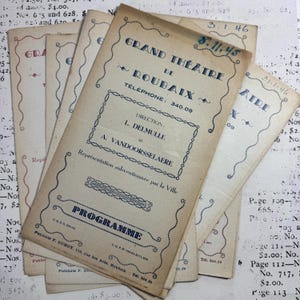 Op de afbeelding: Een vintage programma voor het Grand Théâtre de Roubaix, gedateerd 8.11.45. Het programma is gedrukt op crèmekleurig papier met blauwe inkt en heeft een decoratieve rand. De tekst bevat de naam van het theater, het adres en het telefoonnummer.