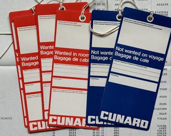 May include: A collection of vintage Cunard luggage tags in red and blue, with white text and string attachments. The tags read "Wanted Baggage" and "Not wanted on voyage". The Cunard logo is prominently displayed.
