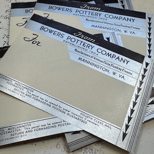 Op de afbeelding: Close-up van vier vintage verzendlabels voor Bowers Pottery Company, opgericht in 1904. De labels zijn gedrukt op wit papier met zwarte en zilveren letters. De labels vermelden "Fabrikanten van sanitair van geglazuurd porselein" en "Mannington, West Virginia."