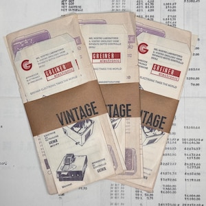 Puede incluir: Paquetes de papel vintage atados con papel marrón, con la palabra "VINTAGE". Los paquetes muestran texto e ilustraciones, incluido el logotipo "GREINER electronic" y diagramas técnicos.