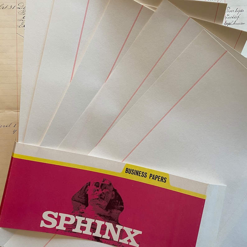May include: A stack of white business papers with red lines, packaged in a red and yellow envelope with the text "SPHINX" and "BUSINESS PAPERS" printed on it.