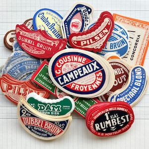 Puede incluir: Una colección de etiquetas de botellas de cerveza vintage que representan diferentes cervecerías y marcas. Las etiquetas son de diferentes colores y estilos, algunas con ilustraciones de lúpulo, cebada y otras imágenes relacionadas con la cerveza. Las etiquetas están todas en holandés.