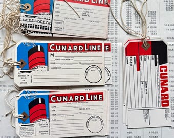 May include: Vintage Cunard Line luggage tags with red, white, and blue accents. Each tag features a ship illustration and spaces for passenger information, including name, ship, and sailing date.