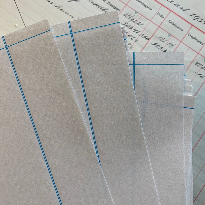 K&ouml;nnte beinhalten: Ein Stapel wei&szlig;es, liniertes Papier mit blauen Linien. Das Papier ist in der Mitte gefaltet und die Kanten sind sichtbar. Das Papier ist leer und es ist nichts darauf geschrieben.