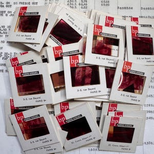 Puede incluir: Un conjunto de diapositivas de película vintage en marcos de cartón blanco, con el logotipo rojo "bp AUDIO-VISUEL". Las diapositivas muestran imágenes de color rojo oscuro y la dirección "3-5, rue Bayard PARIS 8e".