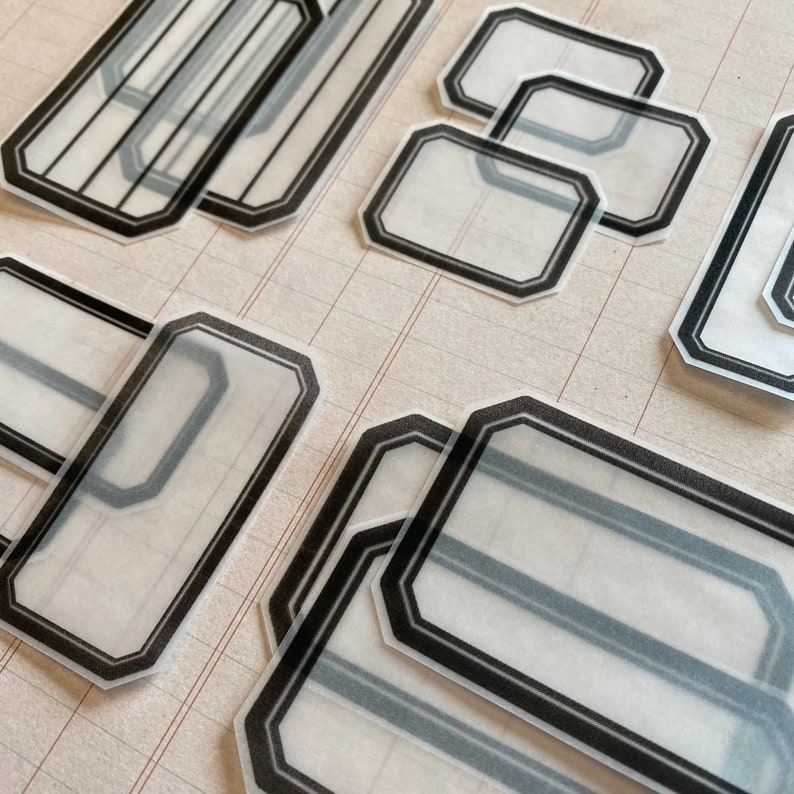 May include: A set of eight black and white decorative labels with a geometric design. The labels are made of clear plastic and have a matte finish.