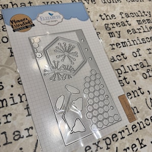 Könnte beinhalten: Klarer Stanzformensatz mit verschiedenen Formen, darunter ein Sechseck, florale Designs und Wabenmuster. Die Verpackung trägt die Aufschrift "Planner Essentials SIDEKICK DIES" und "ELIZABETH craft designs". Für Bastelarbeiten und Scrapbooking.