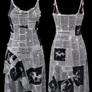 May include: A sleeveless dress featuring a newspaper print pattern with black text and images on a shimmering silver background. The garment has thin gold chain straps and a cowl neckline, with the text Jillusion Couture visible on the fabric.