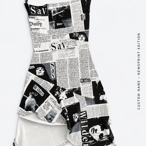 May include: A sleeveless dress featuring a black and white newspaper print pattern with photographic images and the text Sav Wilder Daily Couture. The garment has thin gold-toned chain straps and an asymmetrical hemline with a layered skirt design.