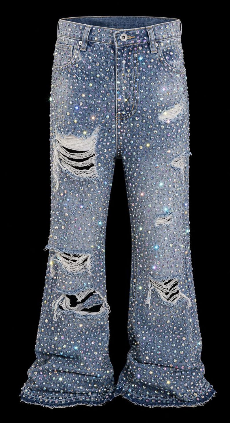 May include: Light blue denim jeans with a flared leg design, heavily embellished with iridescent rhinestones. The jeans feature distressed details with ripped sections throughout the legs, creating a sparkling, edgy look.