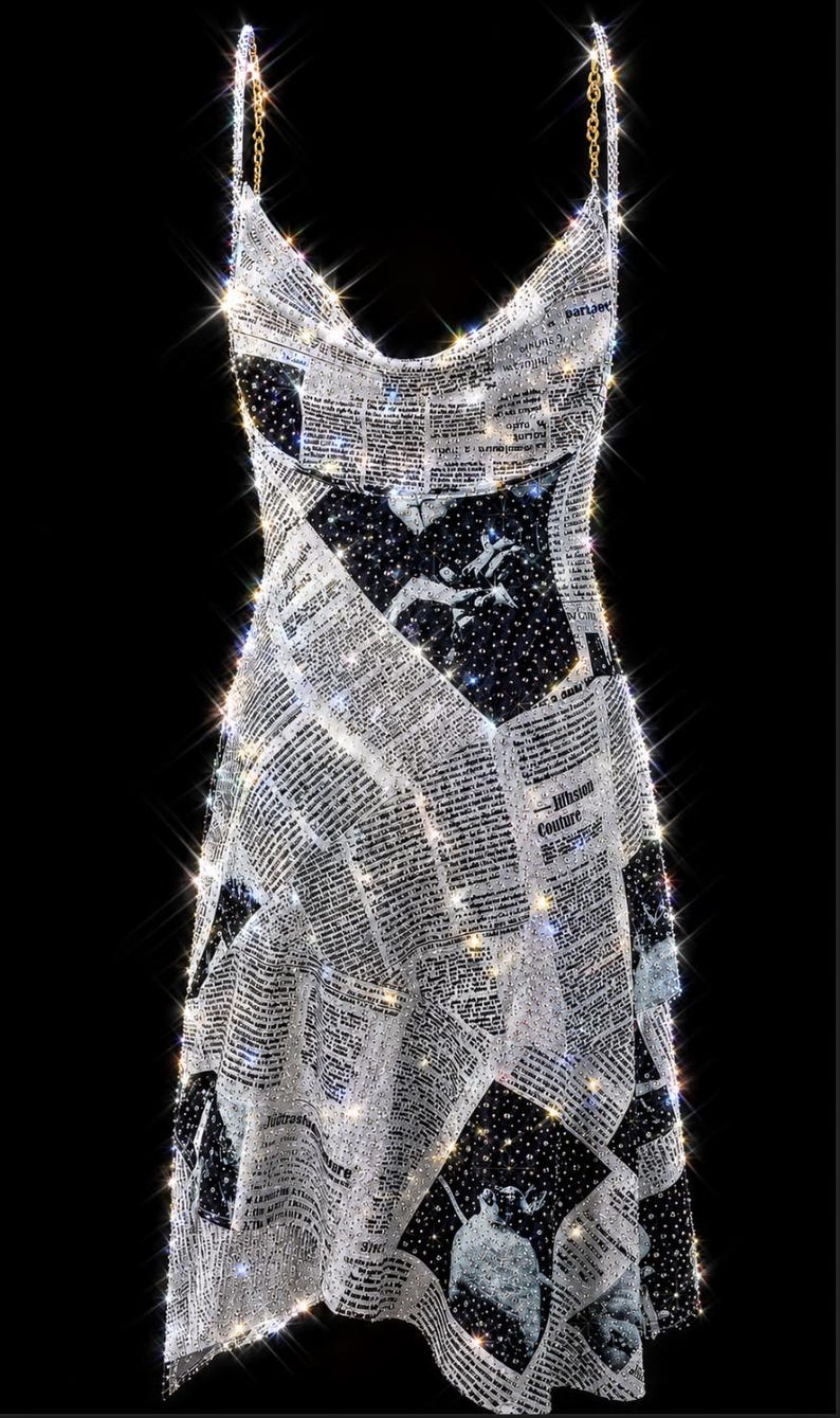 May include: A sleeveless mini dress featuring a newspaper print pattern with black and white text and imagery. The garment is covered in shimmering, reflective embellishments that create a sparkling effect, and it includes thin gold chain straps.