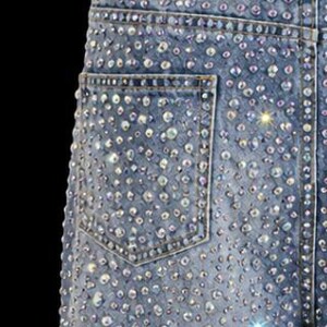 May include: Light blue denim jeans heavily embellished with sparkling rhinestones. The jeans feature a classic five-pocket design and a straight leg cut. The rhinestones are of varying sizes and create a dazzling effect. The jeans are a statement piece.