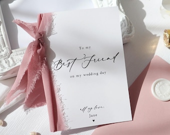 May include: A white card with black calligraphy that reads "To my Best Friend on my wedding day" and "All my love, Jane". The card is tied with a pink ribbon.