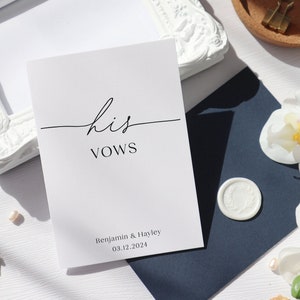 May include: A white card with the text "his vows" in black calligraphy. The card also includes the names "Benjamin & Hayley" and the date "03.12.2024" in black text.