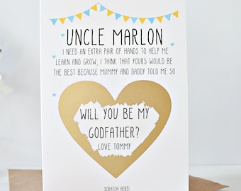 May include: A white card with blue and yellow bunting at the top. The card says "Uncle Marlon, I need an extra pair of hands to help me learn and grow. I think that yours would be the best because Mummy and Daddy told me so." There is a gold heart with a scratch-off area that says "Will you be my Godfather? Love Tommy." 