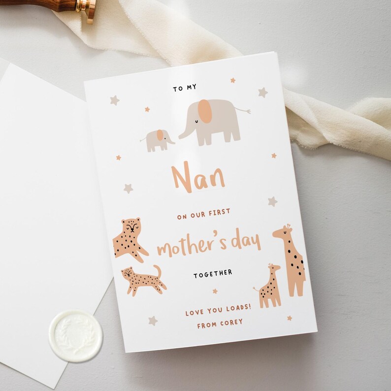 Op de afbeelding: Een witte kaart met een roze en bruine illustratie van dieren, waaronder olifanten, giraffen en luipaarden. De kaart luidt "To My Nan On Our First Mother's Day Together Love You Loads! From Corey."