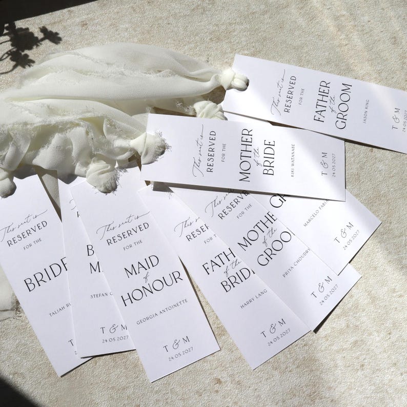 May include: White place cards with black text, reading "This seat is reserved for the Bride", "This seat is reserved for the Maid of Honour", "This seat is reserved for the Mother of the Bride", "This seat is reserved for the Father of the Groom", and "This seat is reserved for the Father of the Groom".