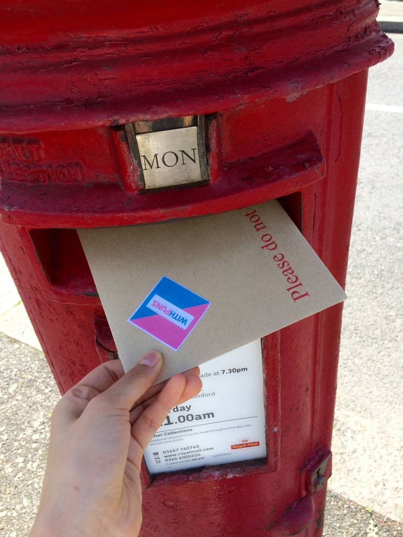 May include: A hand places a brown envelope with a blue and pink sticker that says "WITH PUNS" into a red British post box. The post box has a sign that says "MON" and "Please do not".