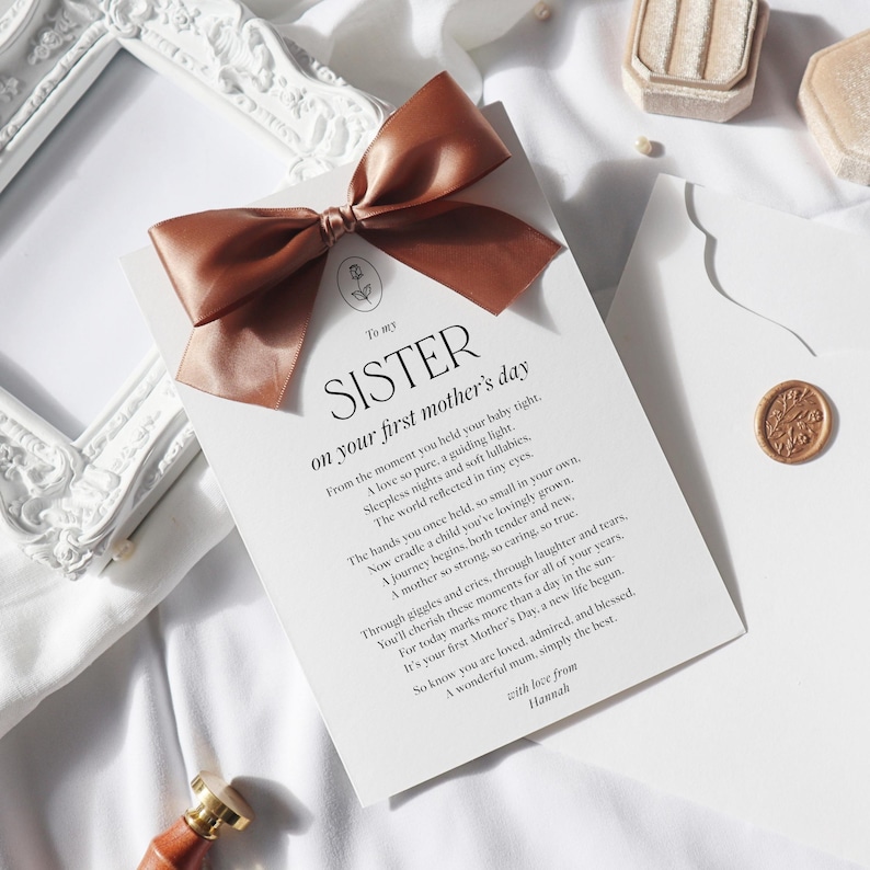 May include: A white card with a brown ribbon tied in a bow. The card has the text "To my Sister on your first mother's day" and a poem about motherhood.