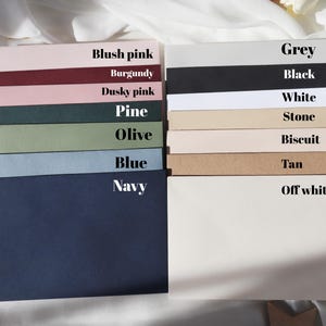 May include: A collection of envelopes in various colors, including blush pink, burgundy, dusky pink, pine, olive, blue, navy, grey, black, white, stone, biscuit, tan, and off-white.