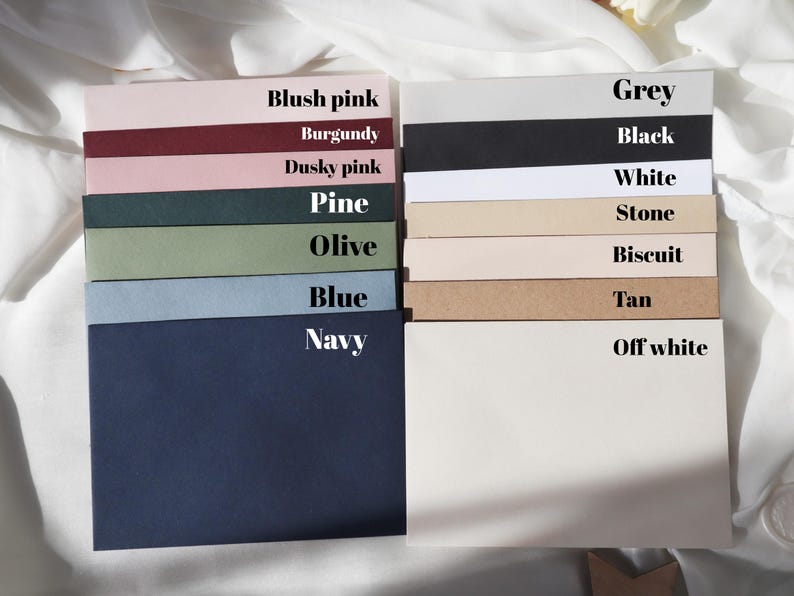 May include: A collection of envelopes in various colors, including blush pink, burgundy, dusky pink, pine, olive, blue, navy, grey, black, white, stone, biscuit, tan, and off-white.