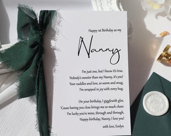 May include: A white card with a green ribbon tied around it. The card has a handwritten message that says "Happy 1st Birthday as my Nanny. I'm just one, but I know it's true, Nobody's sweeter than my Nanny, it's you! Your cuddles and love, so warm and snug, I'm wrapped in joy with every hug. On your birthday, I giggle with glee, 'Cause having you close brings me so much cheer. I'm lucky you're mine, through and through, Happy birthday, Nanny, I love you! with love, Evelyn"