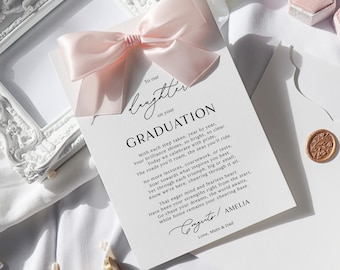 May include: A white graduation card with a light pink satin bow. The card has the words "To our brighter on your GRADUATION" printed in black script. The card includes a poem and is signed "Amelia".