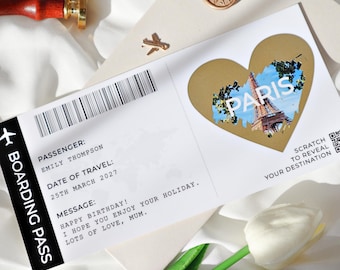 Op de afbeelding: Een witte en gouden instapkaart met een kraslot in de vorm van een hart waarop "Paris" staat en een QR-code. De tekst op de instapkaart luidt "Passagier: Emily Thompson, Reisdatum: 25 maart 2027, Bericht: Gefeliciteerd met je verjaardag! Ik hoop dat je van je vakantie geniet. Veel liefs, Mama."