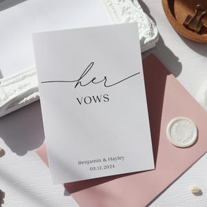 May include: A white card with the text "her vows" in black cursive script. Below the text is the date "03.12.2024" and the names "Benjamin & Hayley".