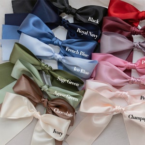 May include: A variety of satin ribbon colors arranged in a fan shape. The colors include black, royal navy, French blue, ice blue, sage green, agave green, chocolate, ivory, vermilion red, mulberry, lavender, princess pink, rose quartz, pearl pink, and champagne.