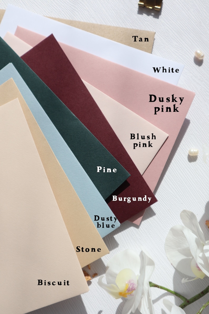 May include: A collection of ten different colored envelopes, arranged in a fan shape. The colors are: Tan, White, Dusky Pink, Blush Pink, Pine, Burgundy, Dusty Blue, Stone, and Biscuit.