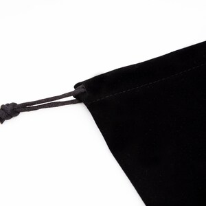 May include: A black velvet drawstring bag with a black cord.