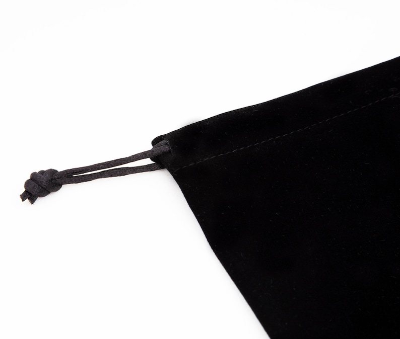 May include: A black velvet drawstring bag with a black cord.