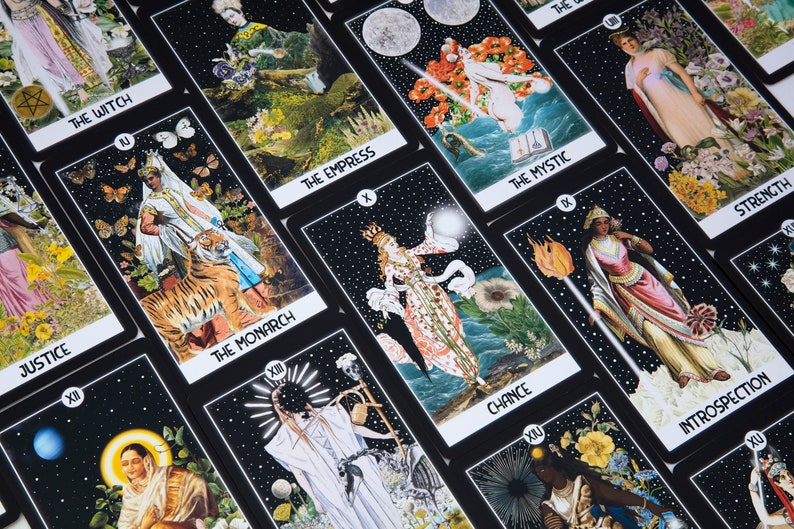 May include: A collection of tarot cards with black borders and various illustrations. The cards feature titles such as "The Witch," "The Monarch," and "The Empress." The artwork includes celestial bodies, figures, and symbolic imagery.