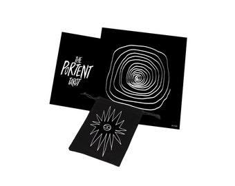 Puede incluir: Baraja de tarot en blanco y negro con una bolsa de terciopelo negro. La bolsa tiene un diseño de estrella blanca con un ojo en el centro. La caja de la baraja de cartas tiene el texto "The Portent Tarot" en blanco.