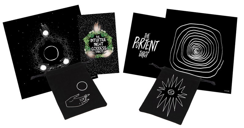 May include: A tarot card set featuring black and white illustrations. The set includes cards with celestial and spiral designs, along with two black drawstring bags. One bag has a hand and circle design, the other has an eye design.
