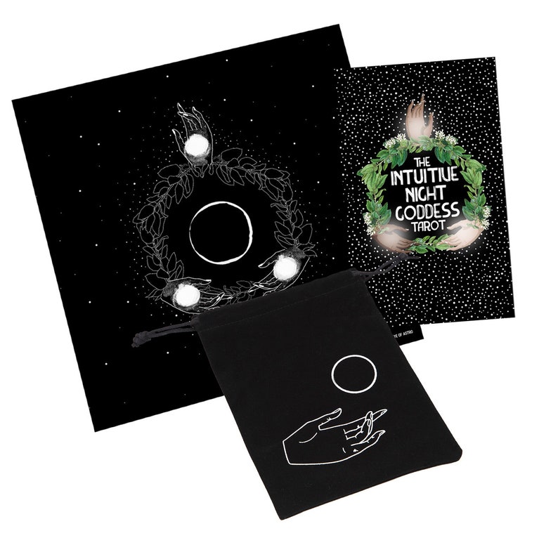 May include: A black velvet bag with a white moon and hand design. The bag is next to a black tarot card deck with a white moon and hand design. The card deck box has the text "The Intuitive Night Goddess Tarot" on the front.