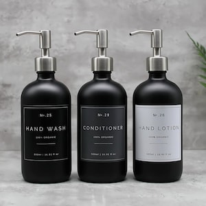 May include: Three black glass bottles with silver pumps and white labels. The labels read "No. 25 Hand Wash 100% Organic", "No. 29 Conditioner 100% Organic", and "No. 26 Hand Lotion 100% Organic".